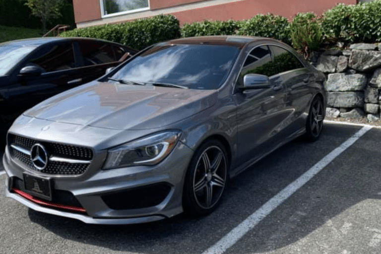 Silver Mercedes CLA sedan parked in front of a building with clean exterior