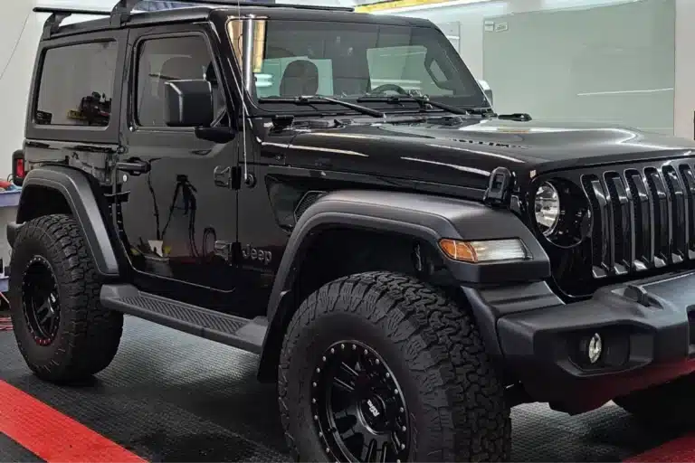 Front side view of a black Jeep Wrangler after paint correction