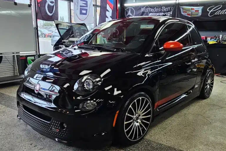 Glossy black vehicle with ceramic coating for enhanced paint protection and shine.