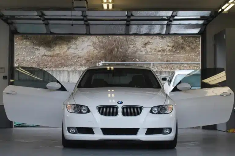 Front view of a white BMW after car detailing in a garage.