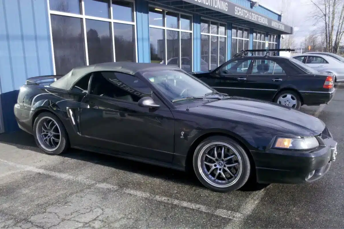Black Ford Mustang parked outside after car detailing.